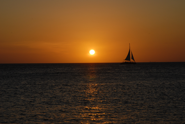 Aruba Wall Art Photography of a sun set cruise sailboat in Palm Beach, Aruba.